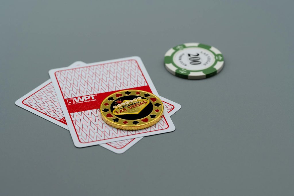 Chip và bài poker trên bàn xanh trong một ván đấu thực tế